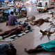 Residents sleep on a pavement to escape heat and frequent power outages in their homes.